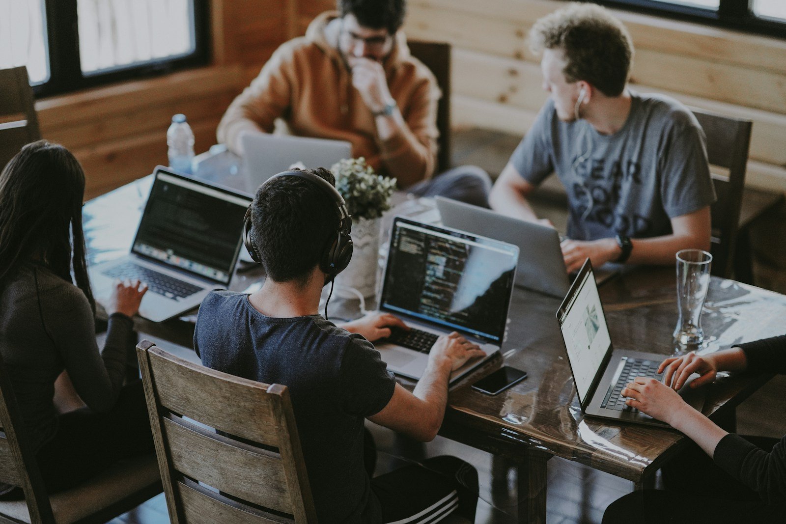 Team collaborating around laptops at a shared workspace